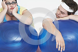 Tired Overweight Couple Resting On Exercise Balls