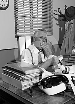 Tired overworked accountant in office, 1950s style