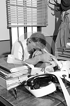 Tired overworked accountant in office, 1950s style