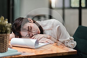 Tired and overworked business woman. Young exhausted girl sleeping on table during her work Entrepreneur, freelance