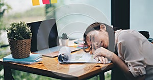 Tired and overworked business woman. Young exhausted girl sleeping on table during her work Entrepreneur, freelance