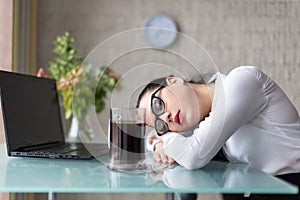 Tired overworked woman sleeping at desk in office