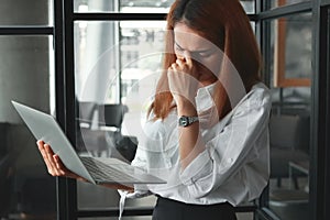 Tired overworked young Asian business woman suffering from severe depression in workplace of office.