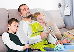 Tired parents with son dressed for cleaning