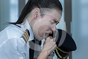 Tired pilot yawning at work