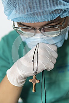 Tired praying doctor at the hospital. A doctor, a nurse who is thinking about treating a disease and a pandemic. Surgeon after