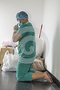 Tired praying doctor at the hospital. A doctor, a nurse who is thinking about treating a disease and a pandemic. Surgeon after