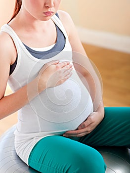 Tired pregnant woman sitting on a fitness ball