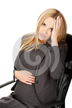 Tired pregnant woman sitting in the office