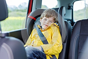 Tired preschool kid boy sitting in car during traffic jam