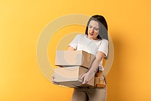 Tired repairwoman holding carton boxes on