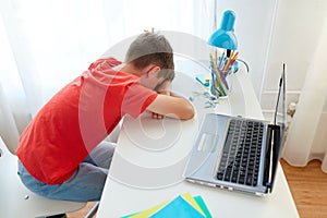 Tired or sad student boy with laptop at home