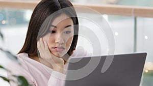 Tired sad upset female face exhausted dissatisfied asian woman manager worker student girl looking at laptop with bored