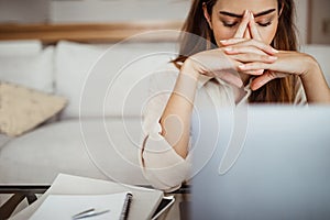 Tired sad young asian woman thinking near computer, suffering from overwork