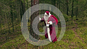 Tired Santa Claus near tree in woods
