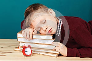 Tired school boy asleep on books. little student sleeping on tex