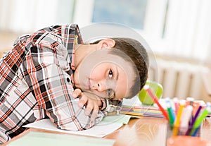 Tired schoolboy in classroom