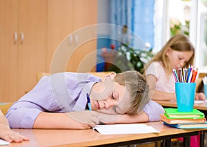 Tired schoolboy at a lesson at school