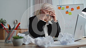 Tired senior business woman use laptop, having nervous breakdown at work, migaine, headache problems