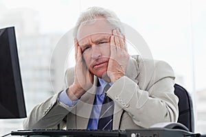 Tired senior manager working with a monitor