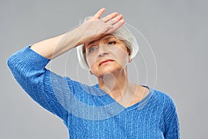 Tired senior woman suffering from headache