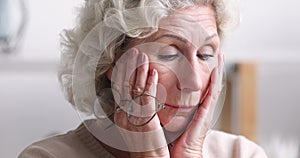 Tired senior woman taking off eyeglasses feeling eye strain concept