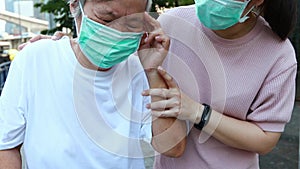 Tired senior woman wearing hygienic mask walk outdoor on street sidewalk in city,feel sick,vertigo,nauseous,allergy to dust,pollut