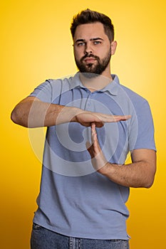 Tired serious upset caucasian man showing pause gesture, stop sign, time out, relax, break, deadline