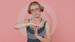 Tired serious upset young redhead woman in dress showing pause gesture, limit or stop sign, time out