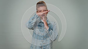 Tired serious upset young toddler kid boy child showing pause gesture, limit or stop sign, time out