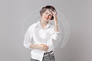 Tired sick young business woman in white shirt posing isolated on grey background. Achievement career wealth business