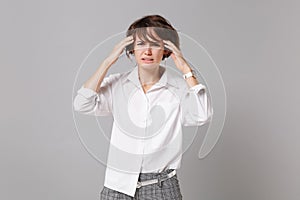 Tired sick young business woman in white shirt posing isolated on grey background studio portrait. Achievement career