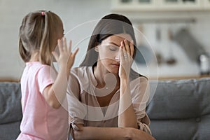 Tired single mother feel desperate about screaming kid daughter photo