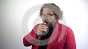 Tired and Sleepy Man.A businessman in a red suit and glasses yawns.