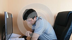 Tired sleepy man working at computer. Typing something.