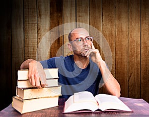 Tired and sleepy mature man on his books, studies to improve his economy