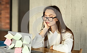 Tired sleepy young woman sitting at desk