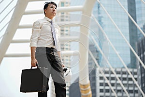 Tired or stressful businessman stand alone in city after working