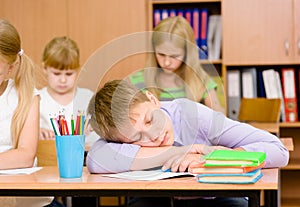 Tired student boy sleeping in classroom