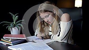 Tired student falls asleep over her notebooks as she prepares for her college lectures.