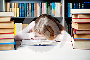 Tired student girl with books sleeping on the table. education, session, exams and school concept .