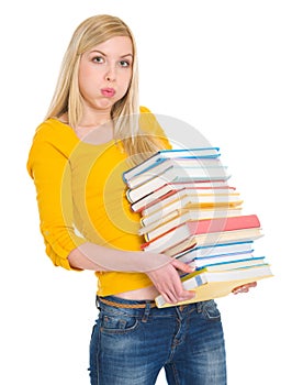 Tired student girl holding pile of books