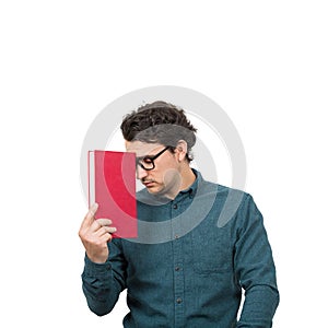 Tired student guy looking down with pessimistic emotion, holding a book, isolated on white background. Confused young man has photo