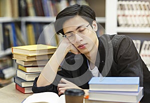 Tired student napping in the university library