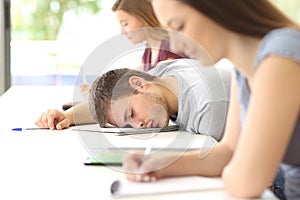 Tired student sleeping in a class at classroom