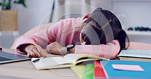 Tired student sleeping at her desk while studying for university or college exams and finals. Exhausted young woman