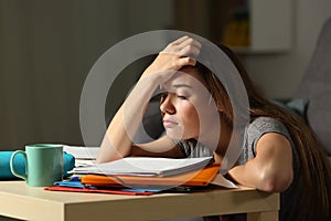 Tired student trying to study in the night photo