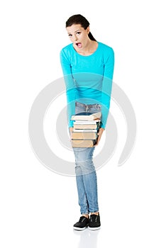 Tired student woman holding heavy books