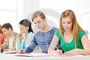 Tired students with textbooks and books at school