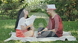 Tired students try to learn educational material in park on green grass